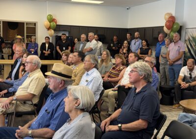 A group of seniors listen intently while sitting down inside a room