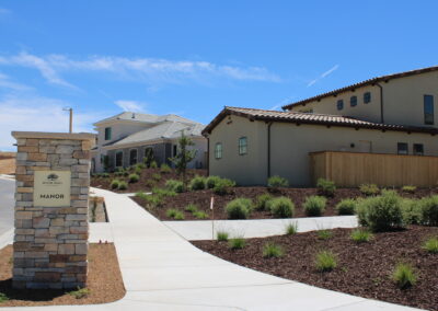 Two houses at River Oaks Reserve with yards and a sidewalk in front