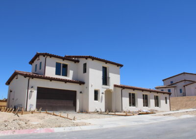A large white house with a street in front and another house on it's right